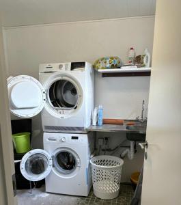 a laundry room with a washer and a washing machine at Midbrekkan apartment in Tvøroyri
