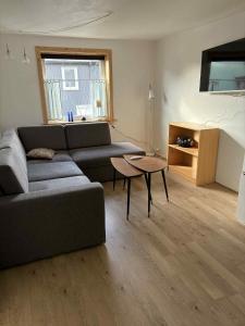 a living room with a couch and a table at Midbrekkan apartment in Tvøroyri