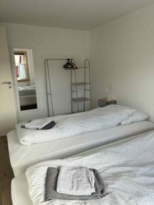 two beds in a room with a mirror at Midbrekkan apartment in Tvøroyri