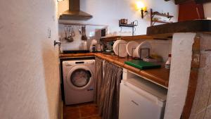 a kitchen with a washer and a washing machine at Ruralux Orcera Linarejos I in Orcera