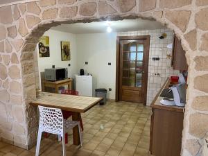 a kitchen with a wooden table and a stone wall at Chez Mady in Kirschnaumen +8 photos