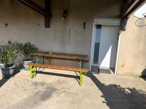 a wooden bench sitting in front of a building at Chez Mady in Kirschnaumen