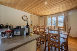 een keuken met een tafel en stoelen en een klok bij Combe Humbert Apartment - Snow and Trek- Morzine in Morzine