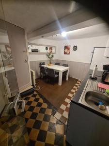 a kitchen with a sink and a table in a room at Haus Tina in Neumagen-Dhron