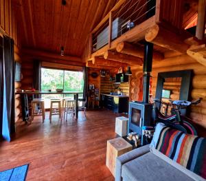a living room with a fireplace in a log cabin at Feel Timber House in Moux-en-Morvan