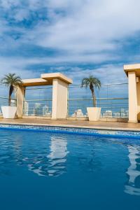una piscina en la azotea de un edificio con palmeras en Flat Congonhas sp, en São Paulo