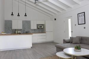 Il dispose d'une cuisine et d'un salon avec un canapé et une table. dans l'établissement Eshae Living - Spacious 2BR with breakfast & pool, à Stanmore Grove