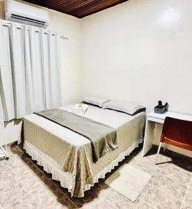 une chambre avec un lit, une fenêtre et un bureau dans l'établissement Casa ao lado do Sebrae, à Macapá