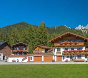 - un grand bâtiment avec des fleurs sur les balcons dans l'établissement Appartmenthaus Geroldhof, à Ramsau am Dachstein