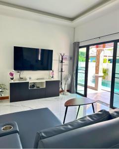 a living room with a tv and a couch at PoolvillaLana 3 rooms in Bang Sare