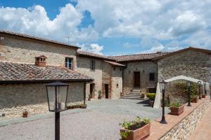 a courtyard of a stone building with a pathway at Monteriggioni Castel Le Torri e Il Borgo in Monteriggioni