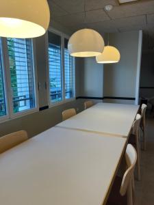 een vergaderruimte met een witte tafel en stoelen bij Centre de la Solitude du Sauveur in Le Mans