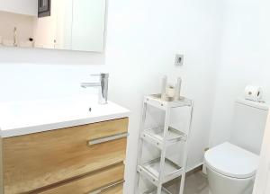 a white bathroom with a toilet and a sink at Casa Bakara La Brisa Zahara Beach in Zahara de los Atunes +12 photos