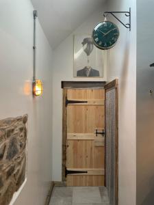a clock on the wall above a door in a room at Pink Cottage in Newton Stewart +100 photos