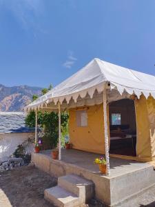 a yellow tent with a porch in a yard at H .R. MOUNT VIEW HOMESTAY. in Nainital +35 photos