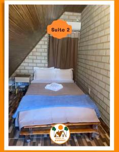 a bed in a room with an orange sign on it at Chalés do AVOHAY, lindo chalé com privativa banheira hidromassagem aquecida, apenas 2 minutos da Vila de São Jorge Chalé Guita in Sao Jorge