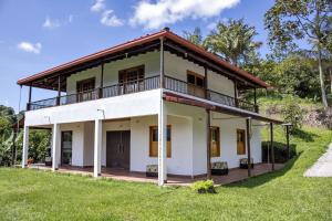 a house on a hill with a green field at Entre Cafetales in Jardin +10 photos