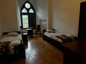 a room with two beds and a desk and a window at Nostra Cultura Zamek Bierzgłowski in Zamek Bierzgłowski