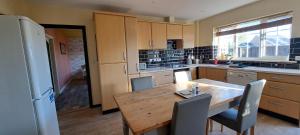 ハンティンドンにあるSizeable 4 bed property on Huntingdon Ring roadの木製のテーブルと冷蔵庫のあるキッチン