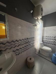 a bathroom with a sink and a toilet and a light at NOLINA BOUTIQUE HOMESTAY in Namchi