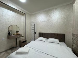 a bedroom with a large white bed and a mirror at Art Home in Tashkent