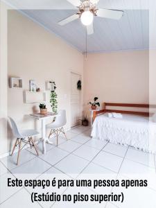 パラチにあるJR 4 · Estúdio no piso superior em Paraty, RJのベッドとテーブルと椅子のある寝室