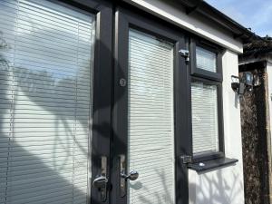 a door to a house with blinds on it at Stylish Detached Studio, Banstead with off street Parking in Banstead