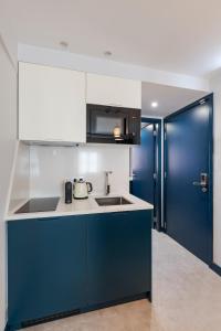 a kitchen with blue and white cabinets and a sink at Ponto Alto Hotel in Lisbon +34 photos