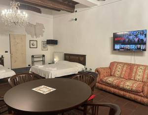 a room with a table and a couch and a bed at Le Dimore della Seta in Lucca