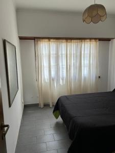 une chambre avec un lit et une grande fenêtre dans l'établissement Departamento Centrico, à Tandil