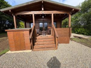 a large wooden building with a porch and stairs at Brynmeini Lake Lodge  +5 photos