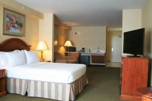 a hotel room with a bed and a flat screen tv at Holiday Inn Express Hotel & Suites Drums-Hazelton by IHG in Drums