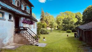 a house with a staircase next to a yard at Pils Parka Apartamenti in Kuldīga