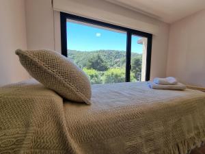 a bedroom with a bed with a large window at ANDES Apartments - PATAGONIA in San Martín de los Andes +27 photos