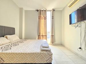 a bedroom with a bed and a large window at En el corazón de Santa Cruz, Departamento de un dormitorio in Santa Cruz de la Sierra