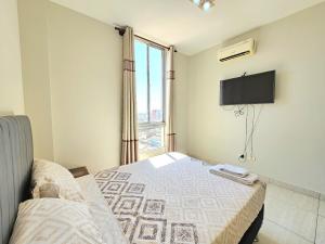 a bedroom with a bed and a tv and a window at En el corazón de Santa Cruz, Departamento de un dormitorio in Santa Cruz de la Sierra