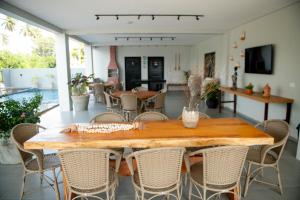 ein Esszimmer mit einem Holztisch und Stühlen in der Unterkunft Apto Vista Mar 2 Suítes Piscina Japaratinga in São Bento