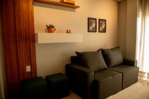 ein Wohnzimmer mit einer Couch und einem Fenster in der Unterkunft Apto Vista Mar 2 Suítes Piscina Japaratinga in São Bento