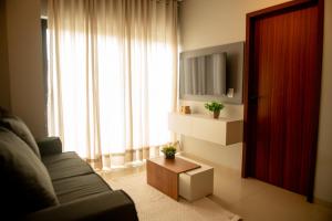 ein Wohnzimmer mit Couch und großem Fenster in der Unterkunft Apto Vista Mar 2 Suítes Piscina Japaratinga in São Bento