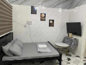 a room with a bed and a tv and a table at CASA Sapphira Transient House in Santo Tomas