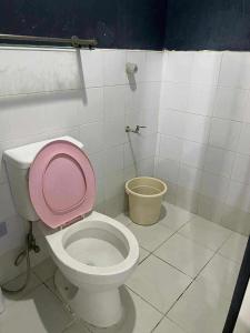 a bathroom with a toilet with a pink lid at CASA Sapphira Transient House in Santo Tomas +11 photos