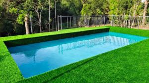 a swimming pool in the middle of a grassy yard at GreensVista Pool Wayanad AC Pillar Homestay near Natural Stream and Amazing View in Panamaram