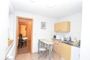 a kitchen with a counter and a table and chairs at Ferienhof Meisdorf - Brückenwohnung in Meisdorf