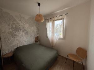 a bedroom with a green bed and a window at Le Nid des Moises, pavillon neuf in Relanges