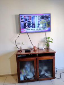 a flat screen tv on top of a wooden entertainment center at Departamento CNH pleno centro SGO CAPITAL in Santiago del Estero