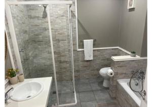 a bathroom with a shower and a toilet and a sink at Pinnacle Golf Villa 24-3 in DʼAlmeida