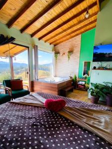 a bedroom with a large bed and a bath tub at Chalé horizonte azul in Gonçalves +67 photos