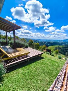 a wooden deck with a gazebo on top of a hill at Chalé horizonte azul in Gonçalves