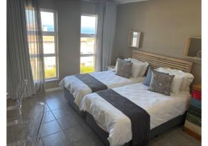 a bedroom with two beds and two windows at Pinnacle Golf Villa 24-3 in DʼAlmeida