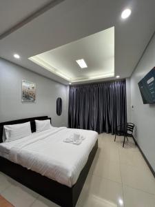 um quarto com uma cama grande e uma janela em PMS Guest House Patong em Patong Beach mais 33 fotografias